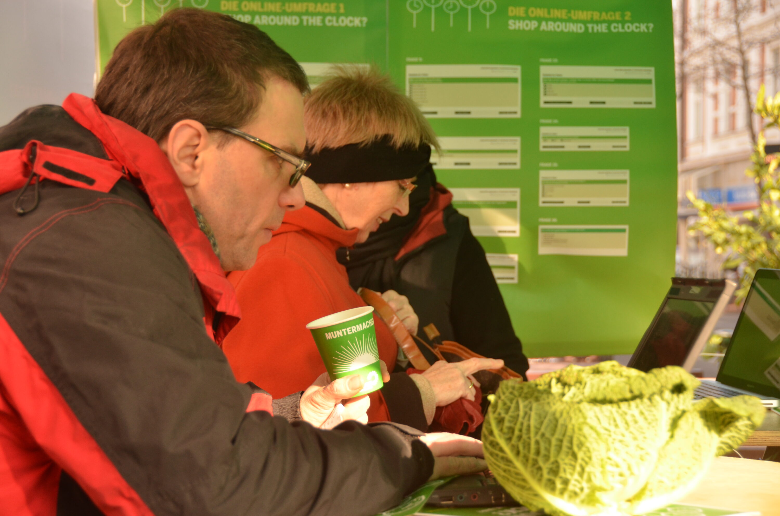 Bürgerinnen und Bürger nehmen teil an der Online-Umfrage der Grünen zu Ladenöffnungszeiten in NRW Man sieht Bürgerinnen und Bürger, die an einem öffentlichen Ort an einer Online-Umfrage der Grünen zu Ladenöffnungszeiten in NRW teilnehmen.